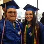 Two graduates smile for the camera